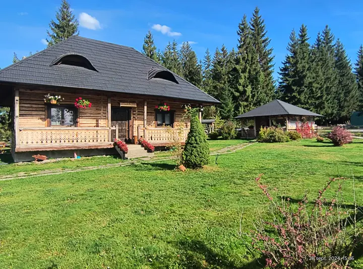 Cabana Căsuța din Povești văzută din curte, cu foișorul în fundal